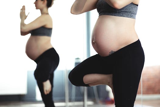 pexels-photo-396133-396133 Pregnant woman doing yoga in front of mirror, promoting health and wellness.